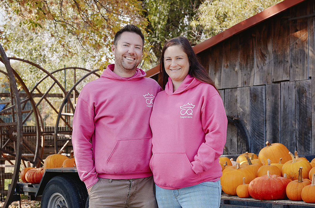 Man and women standing in front of pumpkins