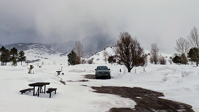 An image of Erik's Volvo XC40 Recharge parked in the snow near a picnic table.