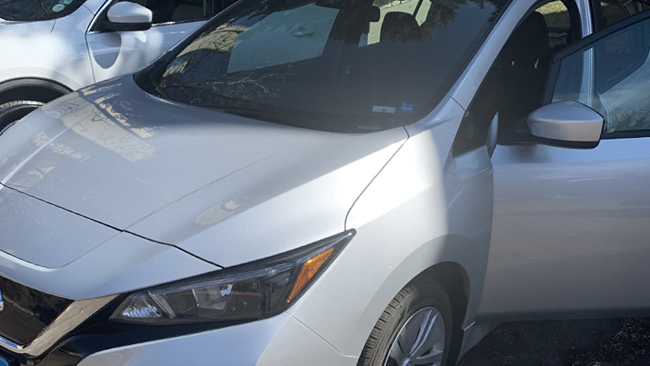 A close-up picture from the front driver's side of the driver's Nissan Leaf.