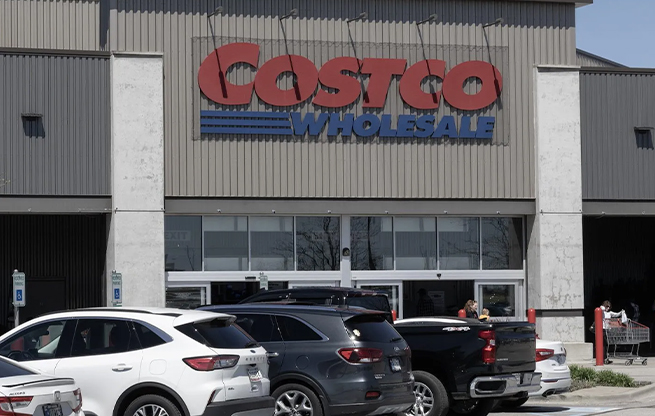 A Costco storefront with cars parked near the front door