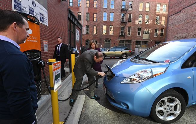 Governor Polis plugging in an electric vehicle