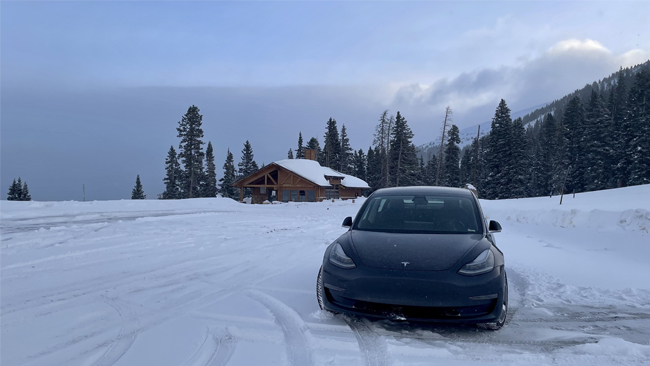 A head-on image of Graeme's Tesla Model 3 parked in a snowscape with a chalet in the background.