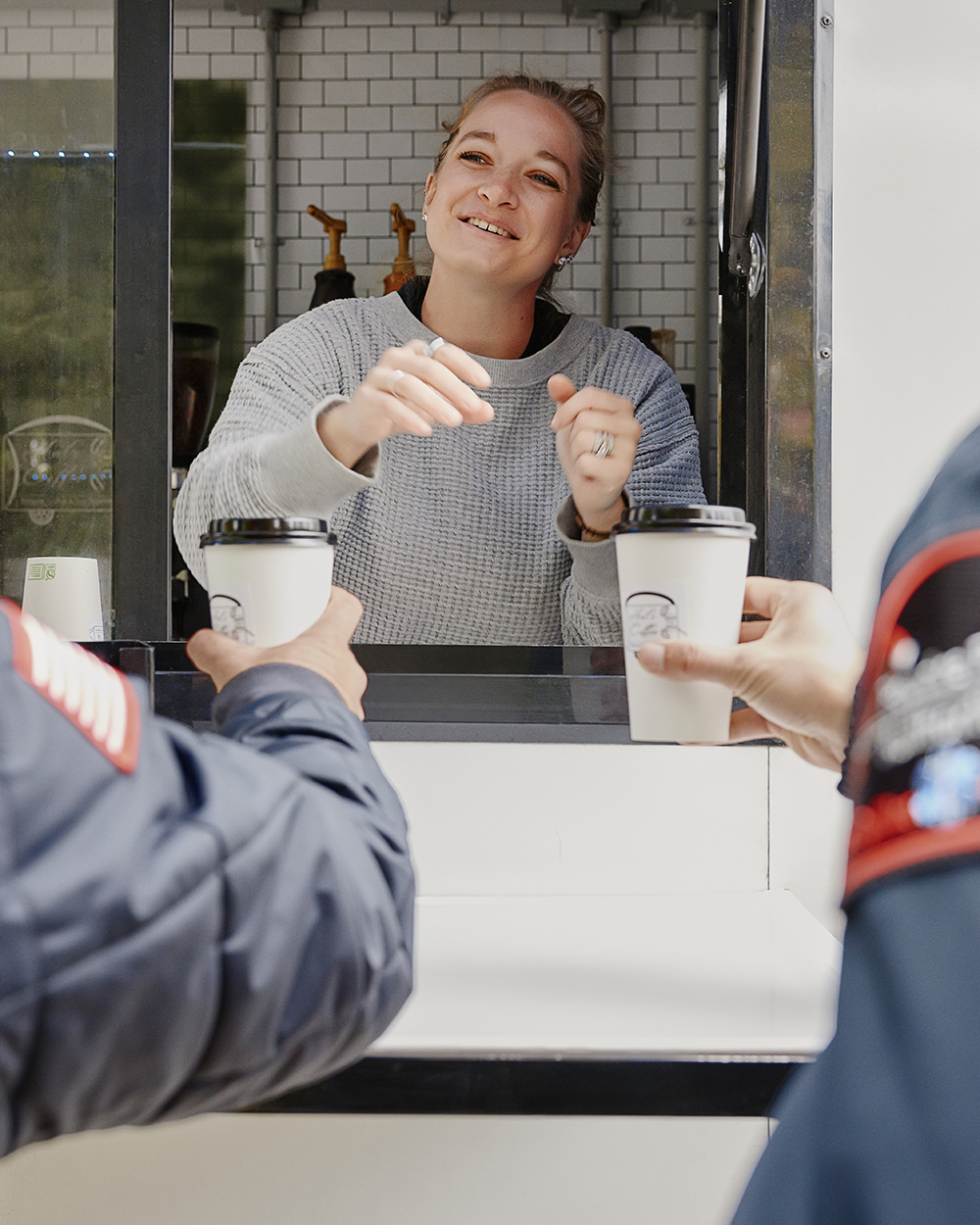 Woman serving coffee out of a window