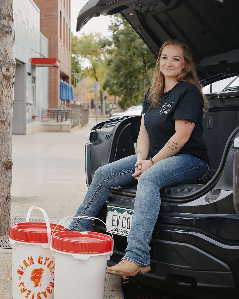 Smiling woman sitting in the front trunk of her TV truck