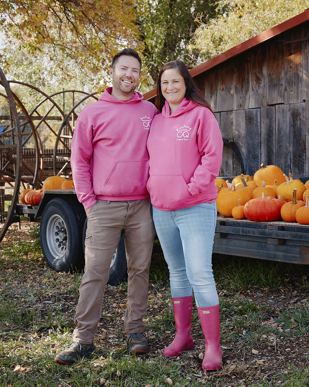 Man and woman standing in front of pumpkins