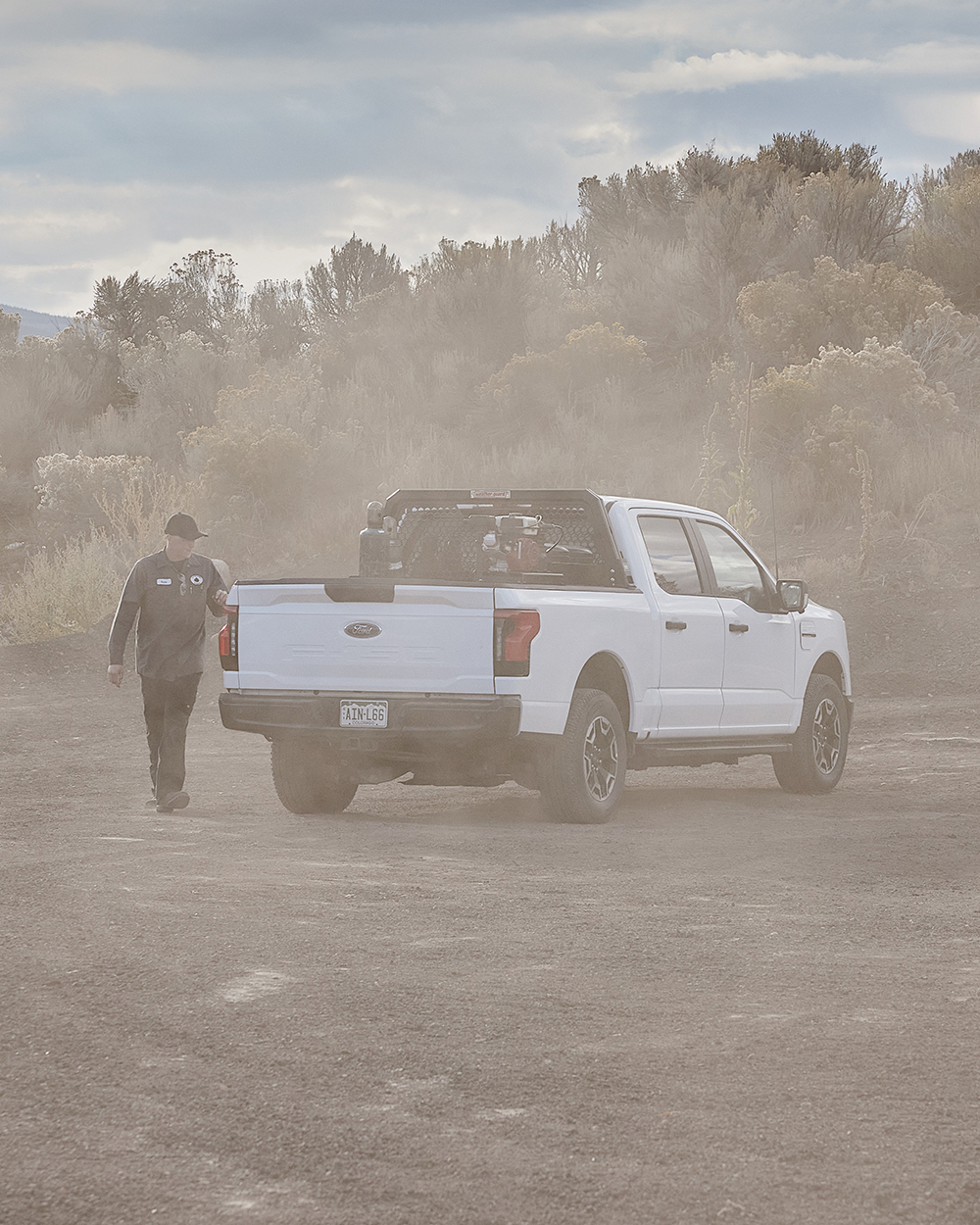 Worker in a dirt field with dust in the air