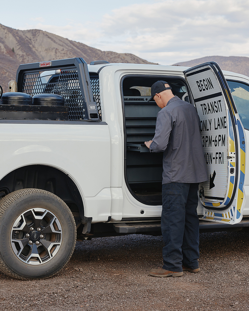 Man looking into back seat of an EV truck