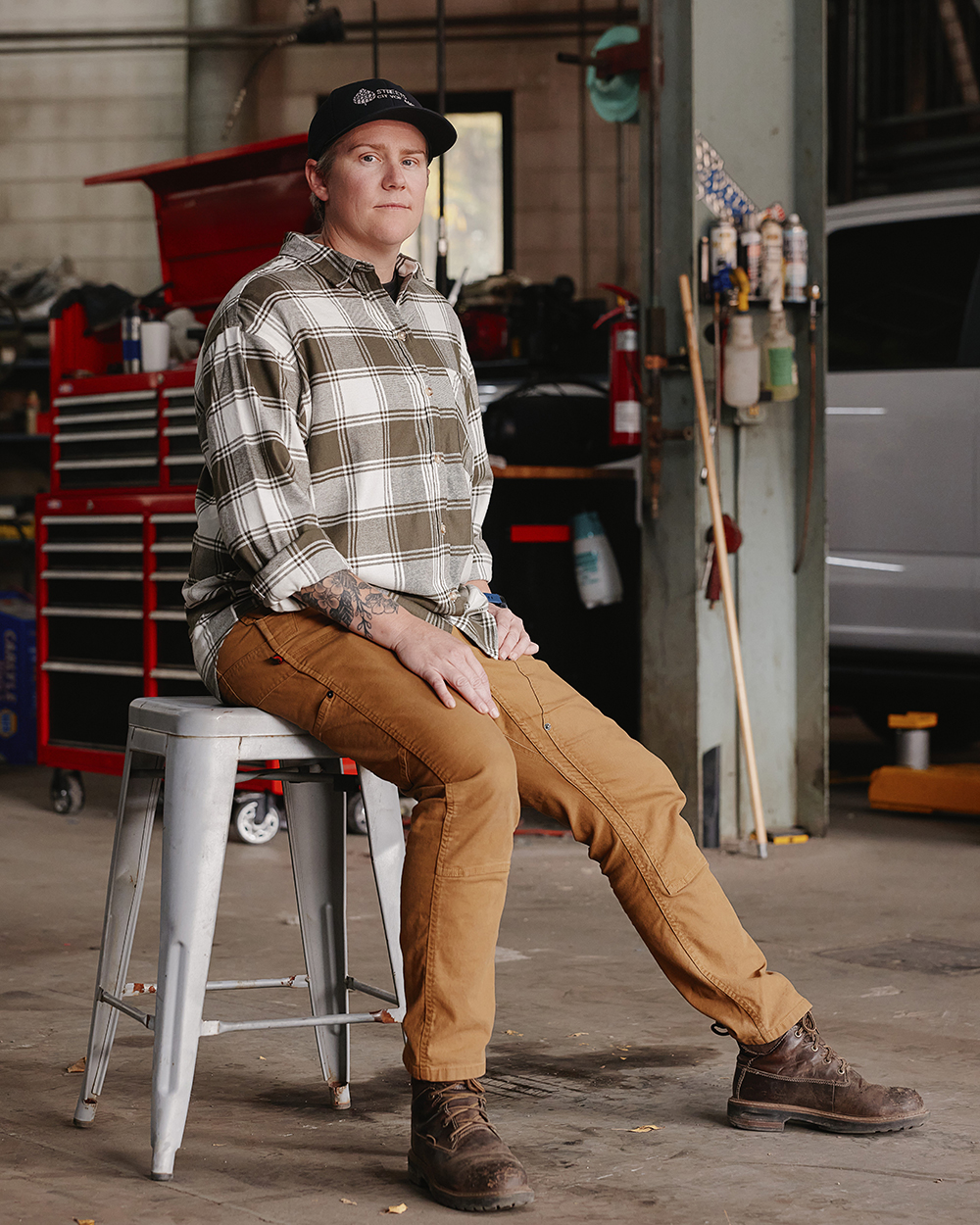 Person sitting on stool in a workshop