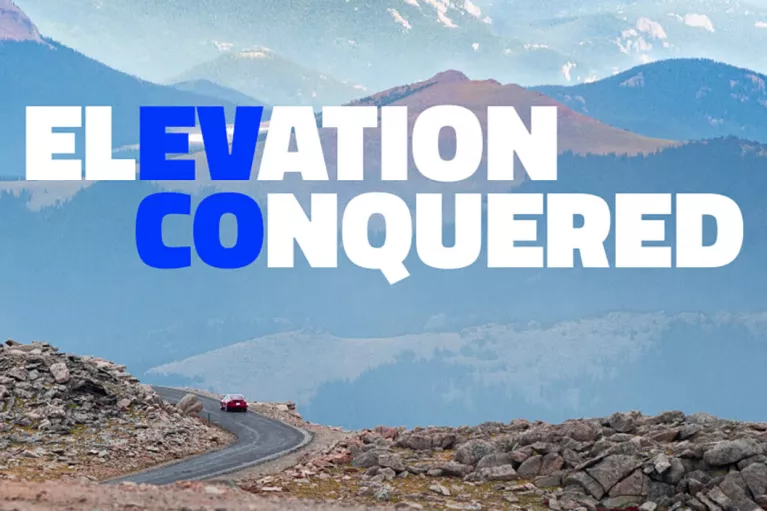 EV CO: Elevation Conquered. An electric vehicle driving through the mountains.