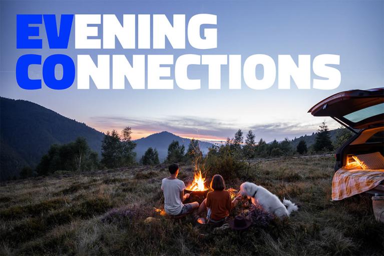EV CO: Evening Connections. A group with their dog enjoying a campfire in the wilderness, near their electric vehicle.