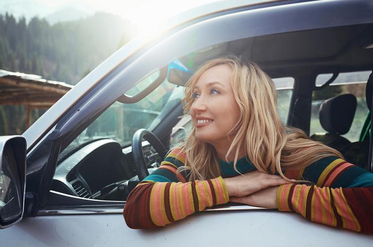 A person looking outside a car window.