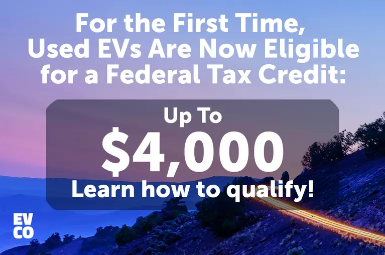 For the First Time, Used EVs Are Now Eligible for a Federal Tax Credit. A lit-up mountain road at dusk.